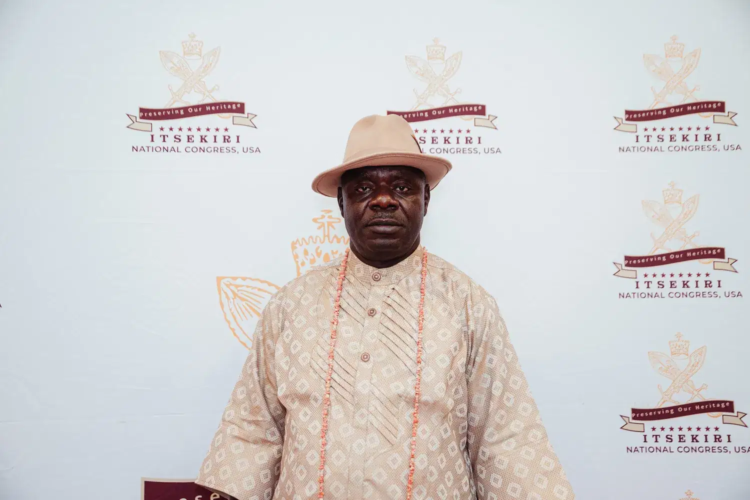 An elder in white and coral beads on the red carpet, Convention 2026, San Francisco