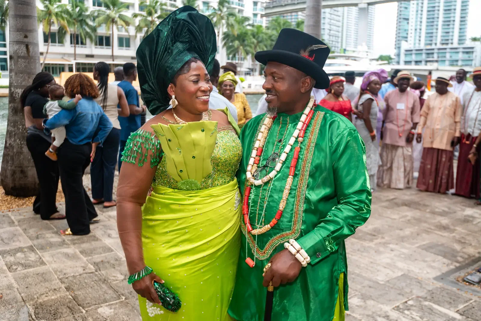 A couple in green with coral beads on the riverwalk, Convention 2025, Miami